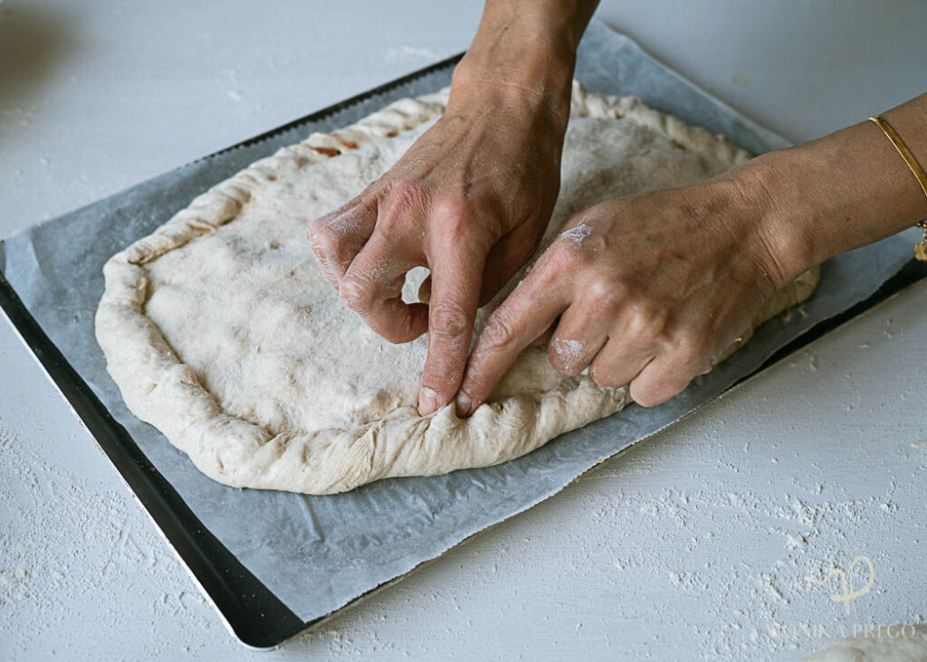 Haciendo los repulgues de la empanada gallega casera